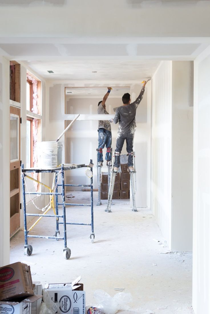 Grupo Constructor Medina craftsmen finishing drywall on stilts
